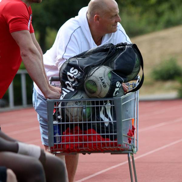 Der frühere ETSC-Trainer Hartmut Pitten lehnt beim Saisonauftakt gegen den SC Wißkirchen an einem Einkaufswagen, in dem die Ersatzbälle transportiert sind.
