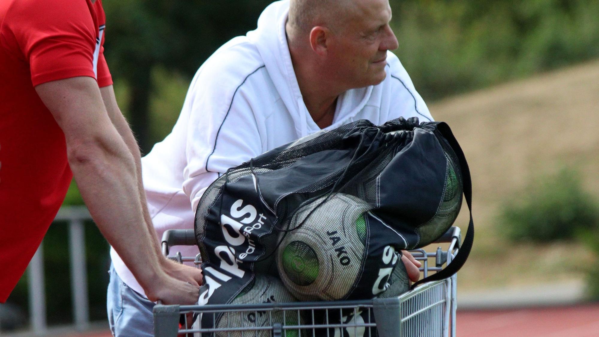 Der frühere ETSC-Trainer Hartmut Pitten lehnt beim Saisonauftakt gegen den SC Wißkirchen an einem Einkaufswagen, in dem die Ersatzbälle transportiert sind.