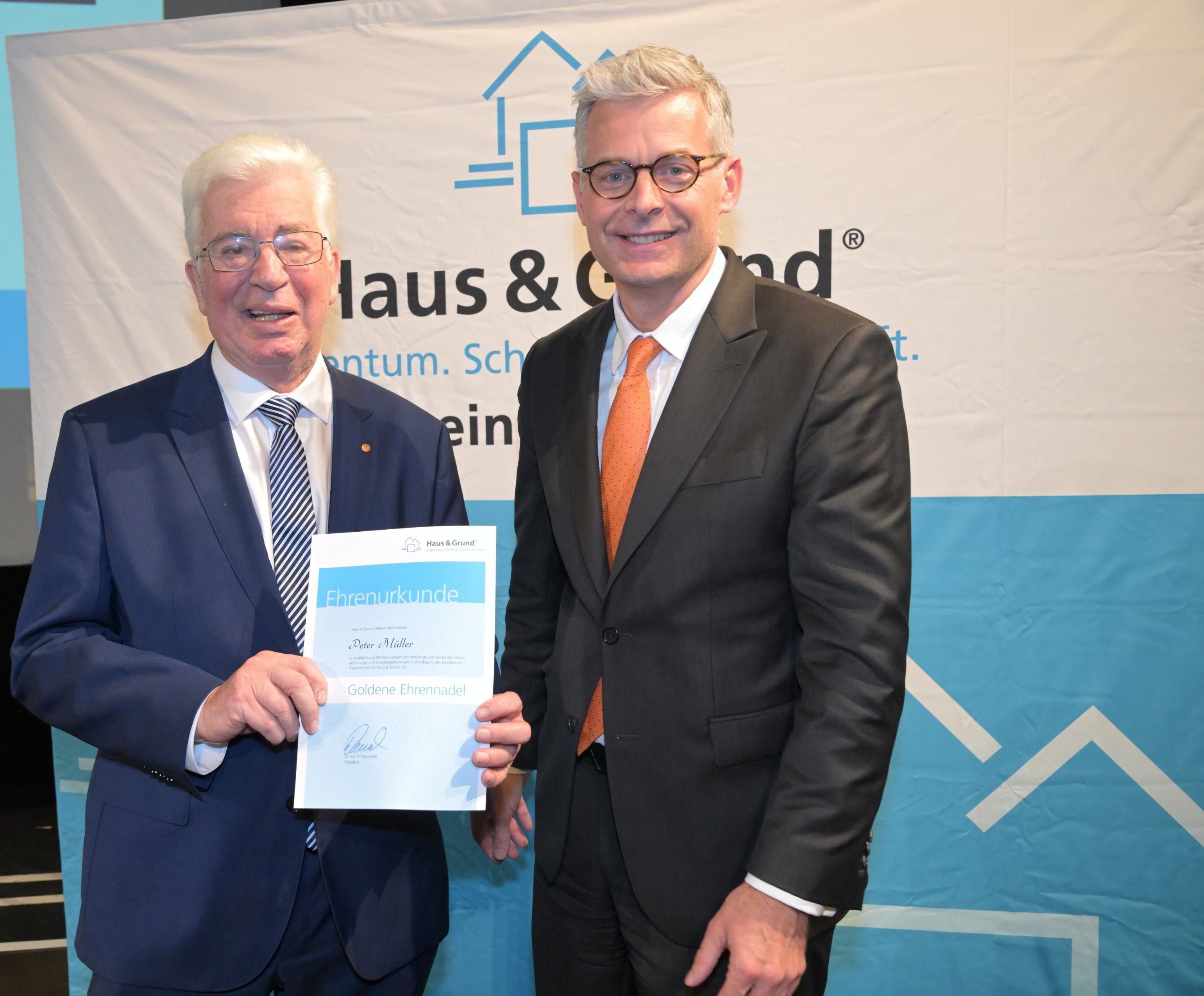 Der Vorsitzende von Haus und Grund Bergisch Gladbach, Peter Müller, hält eine Ehrenurkunde in der Hand, die Kai Warnecke, Bundespräsident von Haus und Grund, ihm überreicht hatte.