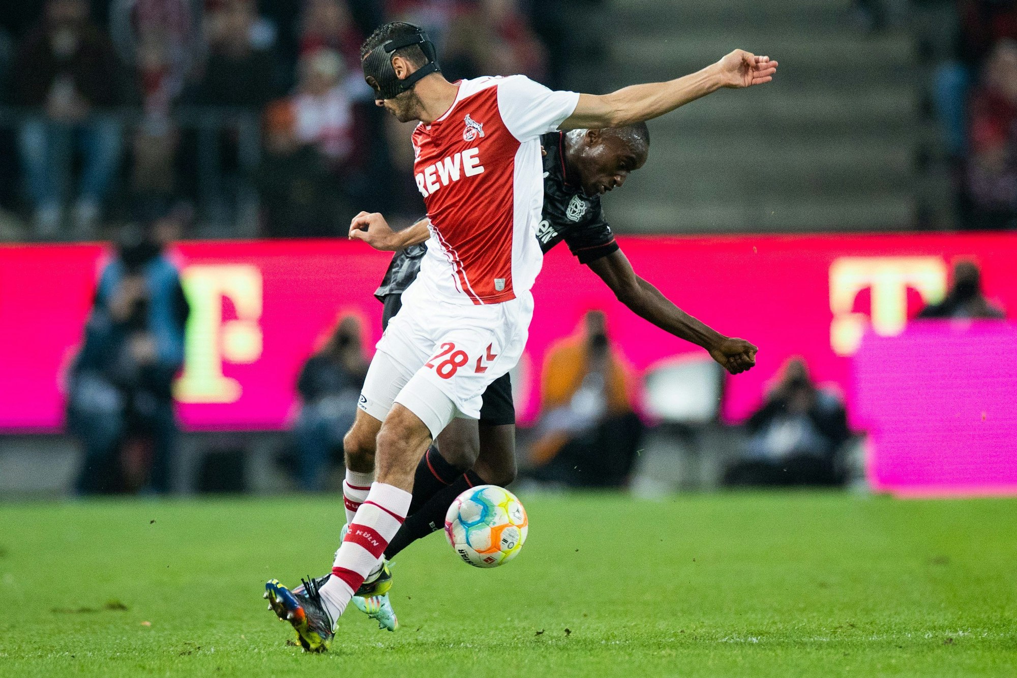 Kölns Ellyes Skhiri (l) und Leverkusens Moussa Diaby versuchen an den Ball zu kommen.