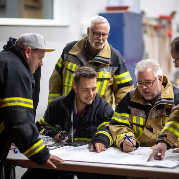 Die Feuerwehrleute der Löschgruppe Dom-Esch sitzt über einem Schichtplan zusammen.