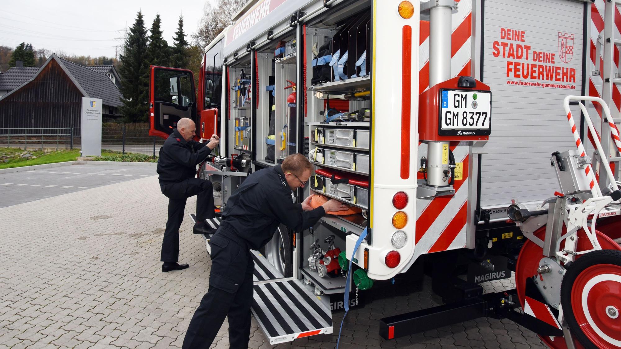 Zwei Gummersbacher Feuerwehrkameraden zeigen das Innere des neuen Hilfeleistungslöschgruppenfahrzeugs.