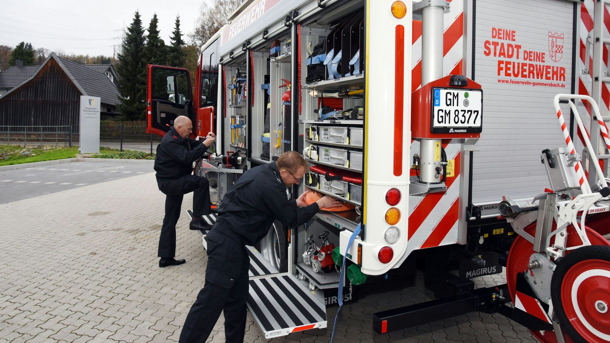 Zwei Gummersbacher Feuerwehrkameraden zeigen das Innere des neuen Hilfeleistungslöschgruppenfahrzeugs.