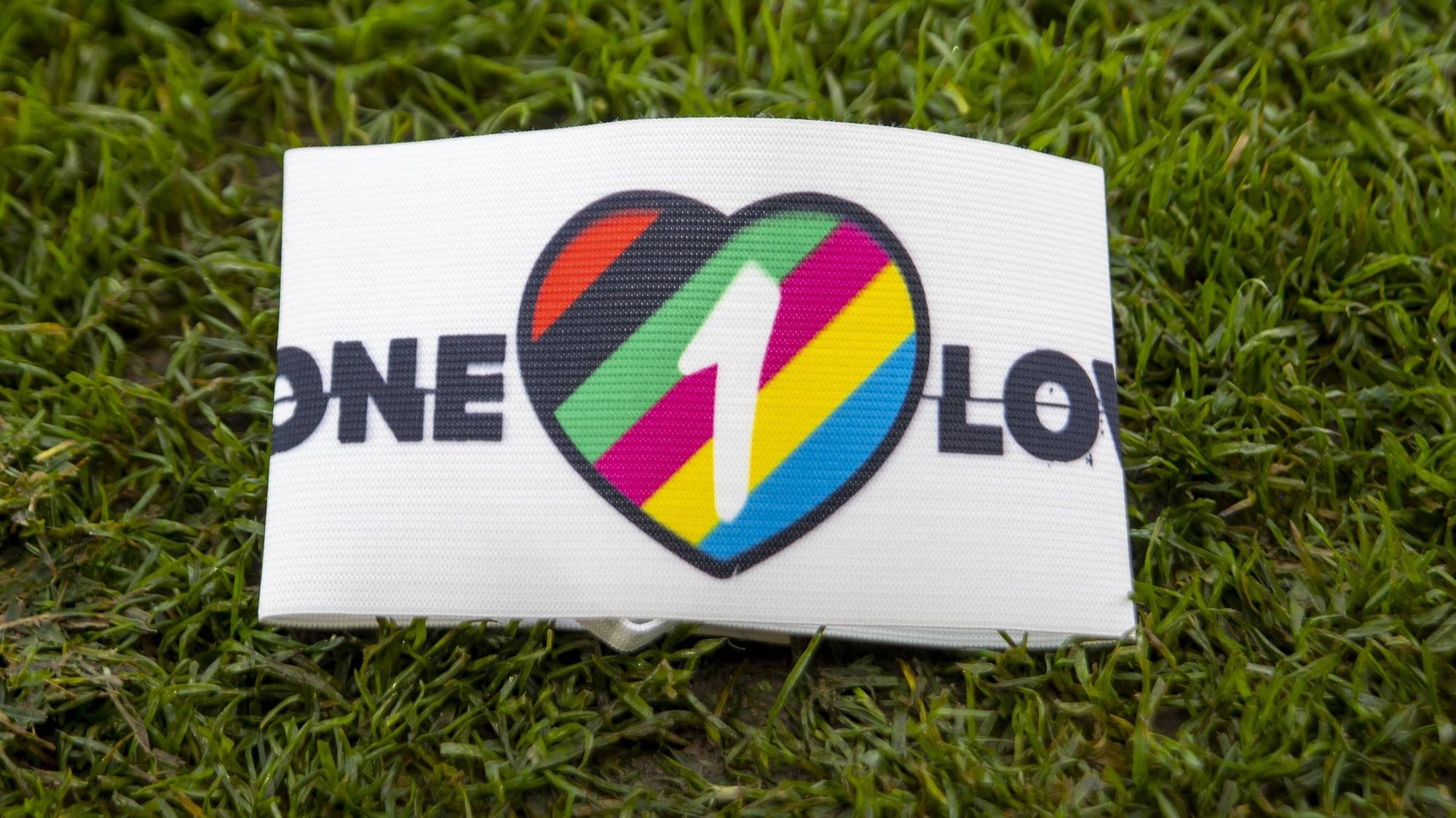 Die One Love-Armbinde liegt auf einem Rasenstück.