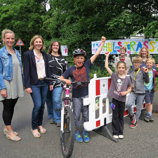 Schüler der Grundschüler Diesterwegstraße, Lehrer und Eltern präsentieren ihre selbsteingerichtete Straßensperrung vor der Schule.