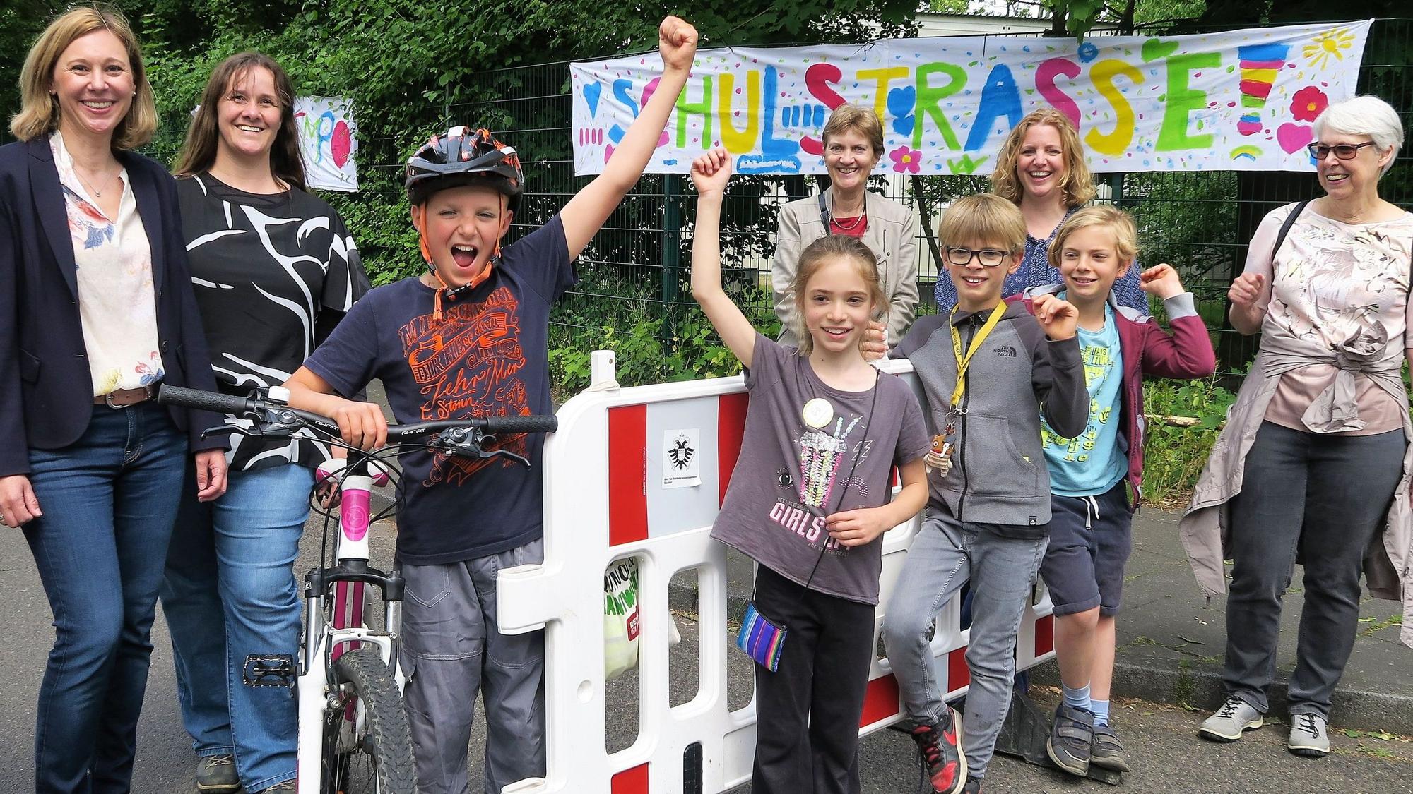Schüler der Grundschüler Diesterwegstraße, Lehrer und Eltern präsentieren ihre selbsteingerichtete Straßensperrung vor der Schule.