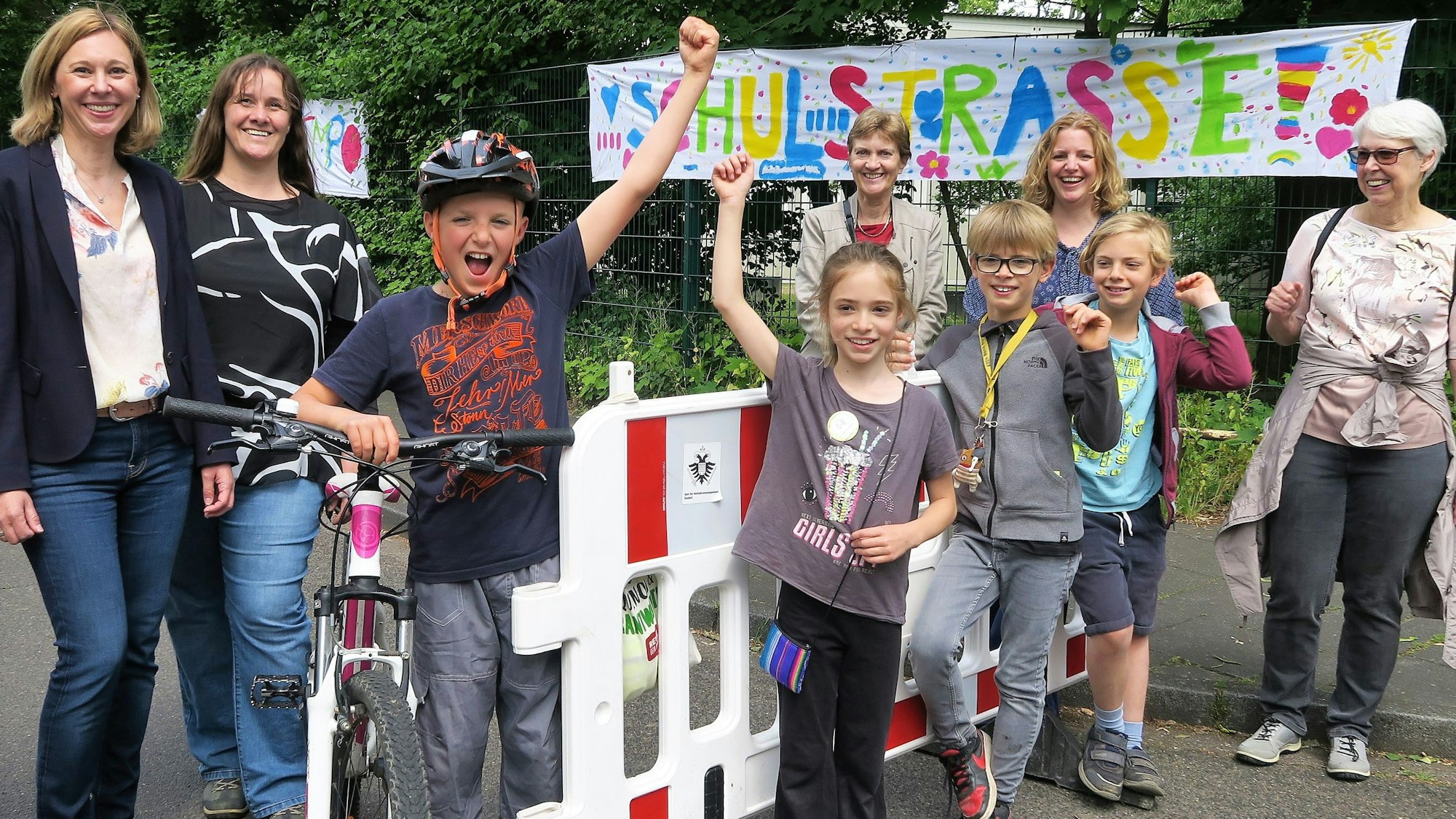 Schüler der Grundschüler Diesterwegstraße, Lehrer und Eltern präsentieren ihre selbsteingerichtete Straßensperrung vor der Schule.