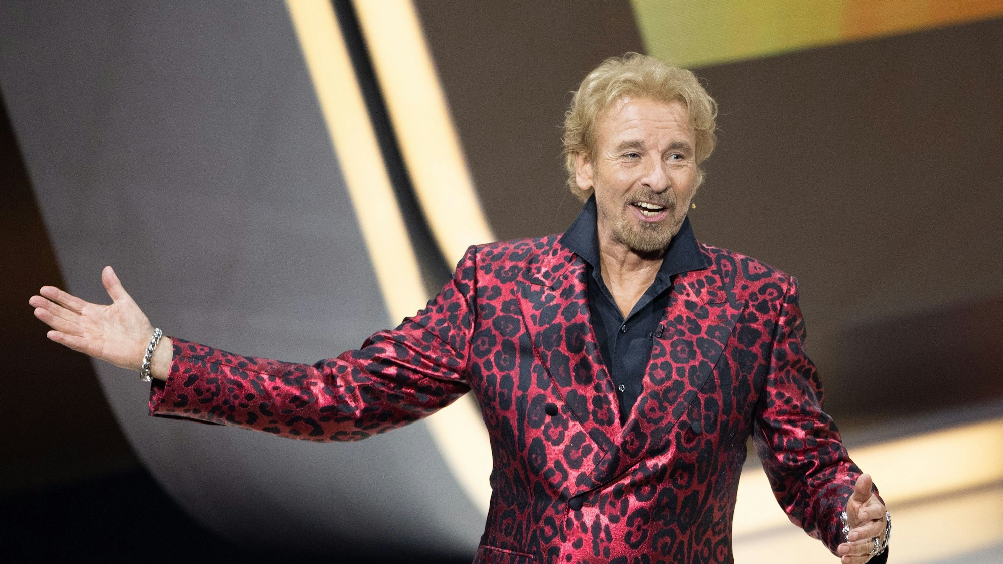 Moderator Thomas Gottschalk kommt bei „Wetten, dass..?“ in Friedrichshafen auf die Bühne. Er trägt einen rot-glänzenden Anzug mit Leoparden-Muster.