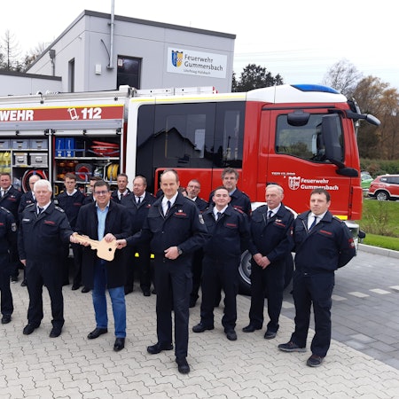 Bürgermeister Frank Helmenstein hält symbolisch für die Fahrzeugübergabe einen großen goldenen Schlüssel in der Hand. Diesen übergibt er an Feuerwehrchef Frank Raupach und die stellvertretenden Einheitsführer Stephan Schulte und Kai Alberts.