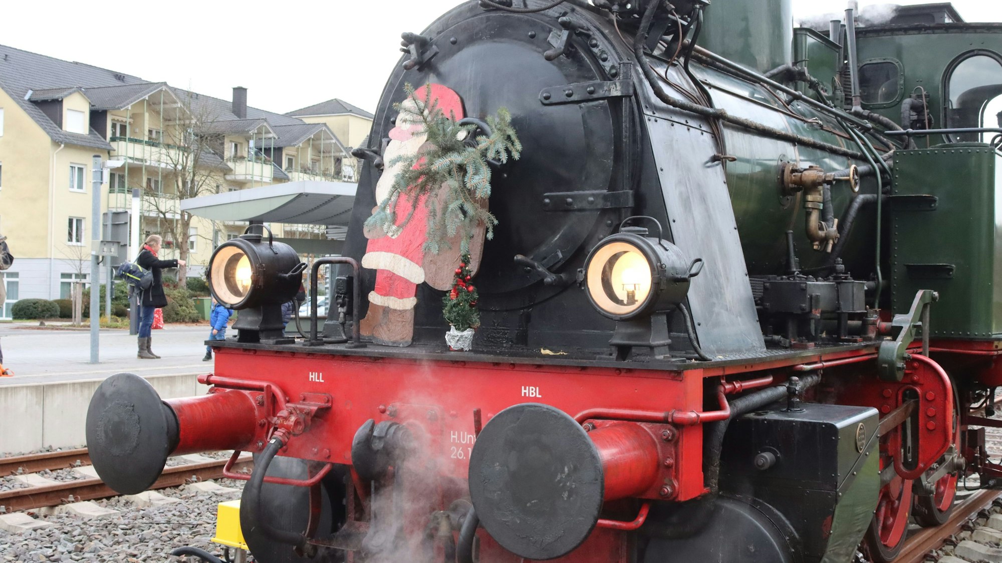 Eine alte Dampflok ist weihnachtlich dekoriert, mit Nikolaus, Tannenzweigen und einem kleinen Weihnachtsbaum.