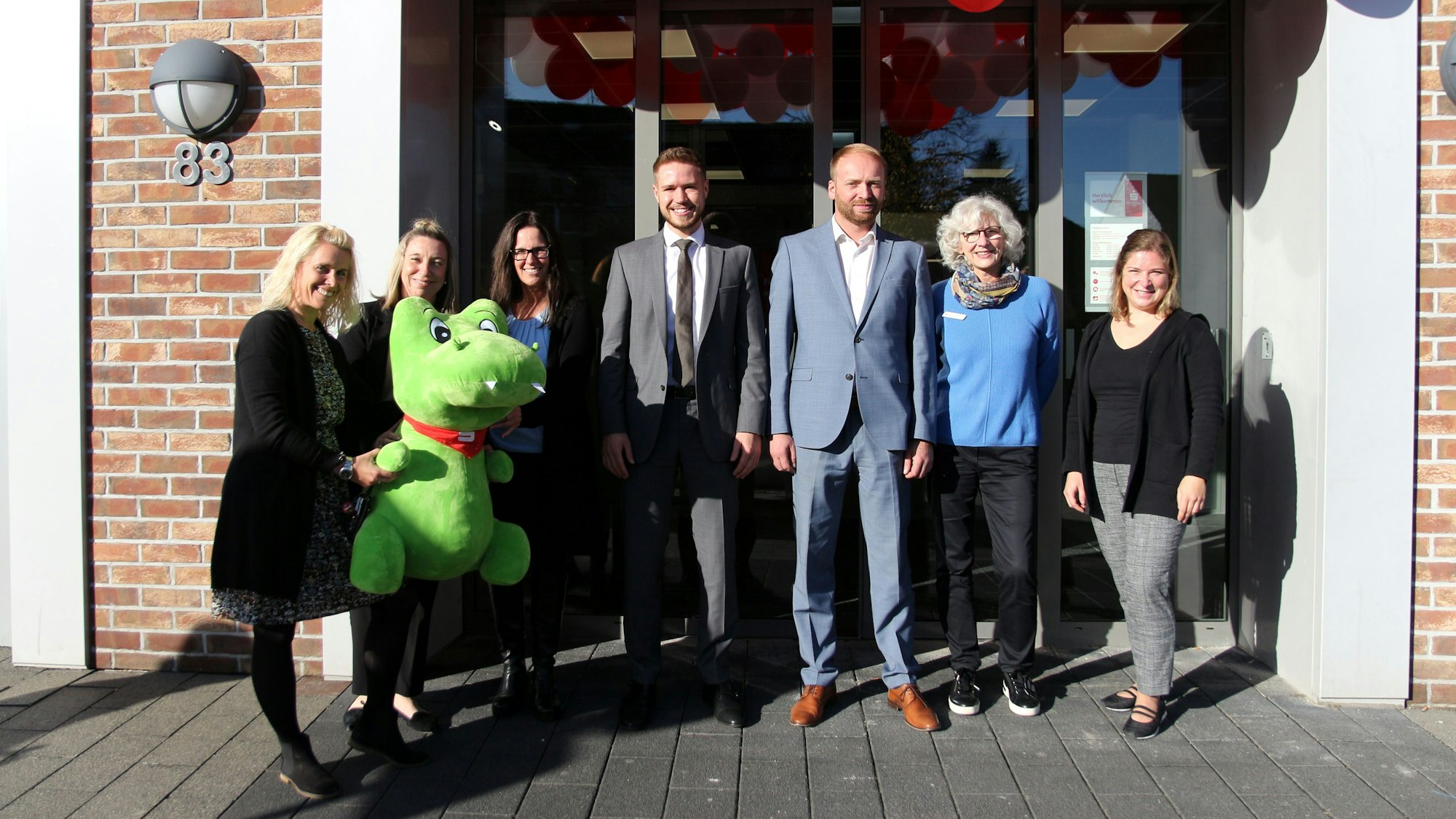 Mitarbeiter stehen vor dem Eingang der wiedereröffneten Filiale in Stommeln.