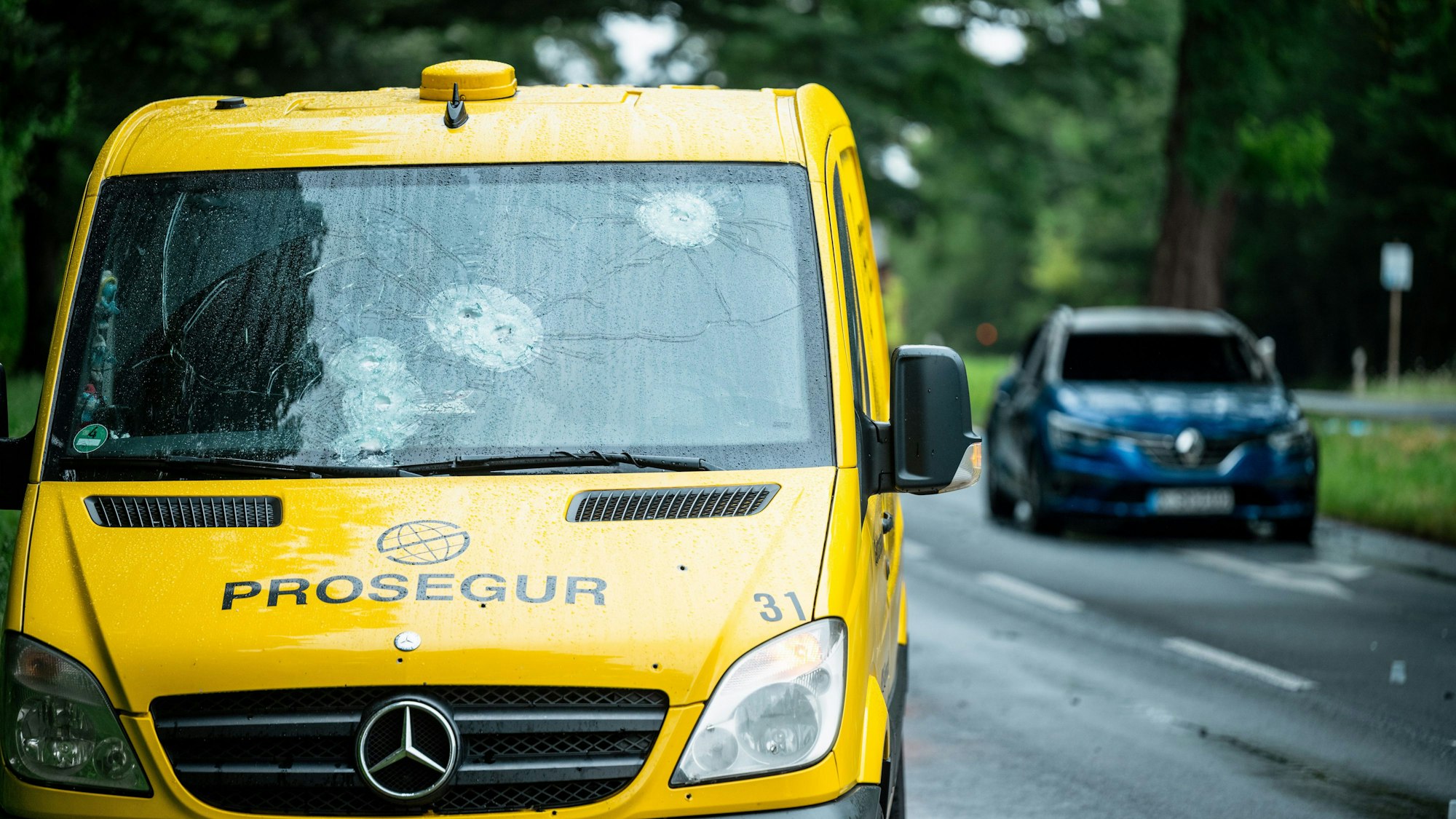 Ein durch Schüsse beschädigter Geldtransporter steht am Straßenrand.
