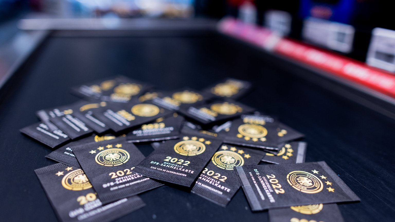 Nordrhein-Westfalen, Köln: Sammelkarten zum offiziellen DFB-Sammelalbum zur Fußball-Weltmeisterschaft in Katar liegen im Kassenbereich eines Rewe Marktes.