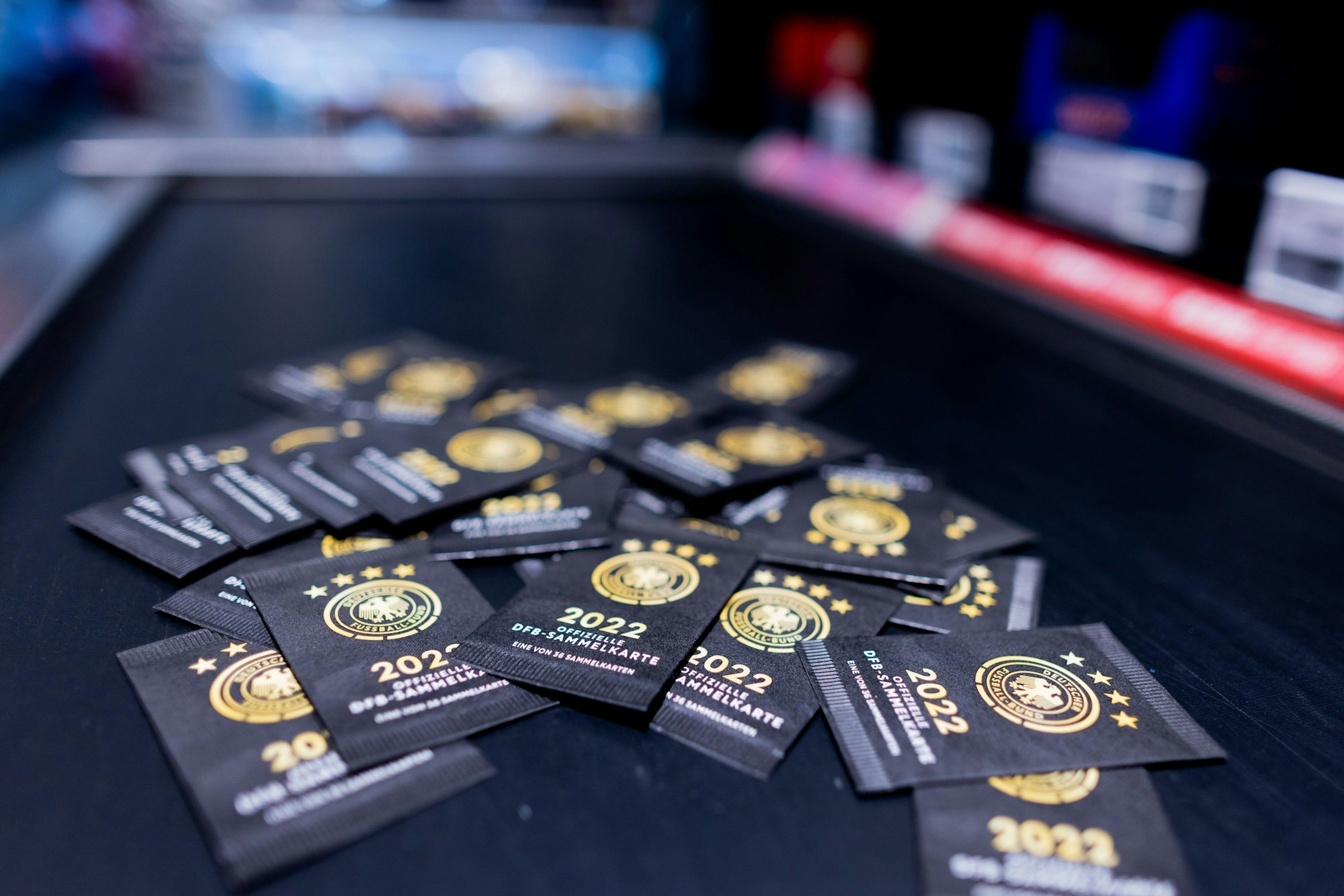 Nordrhein-Westfalen, Köln: Sammelkarten zum offiziellen DFB-Sammelalbum zur Fußball-Weltmeisterschaft in Katar liegen im Kassenbereich eines Rewe Marktes.