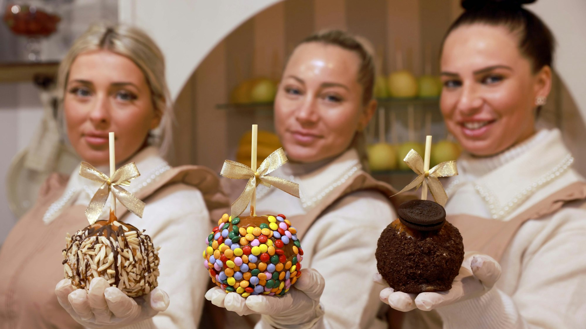 Heinzelmännchen mit süß verzierten Äpfeln: (v.l.) Chiara Coco, Michelle Cardinale, Sammy Fei von der „Zuckerbäckerei“.
