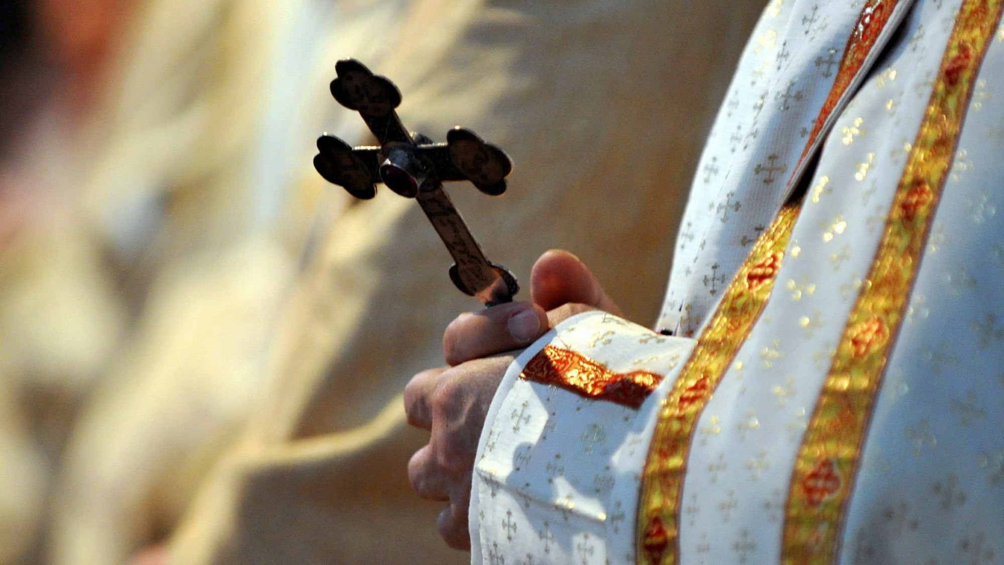 ARCHIV - 16.05.2010, Bayern, München: Ein Bischof hält während einer katholischen Messe ein Kreuz in den Händen.