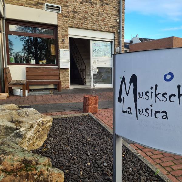 Ein Schild weist auf das Gebäude, in dem in Bergheim sich der Hauptsitz der Musikschule La Musica befindet.