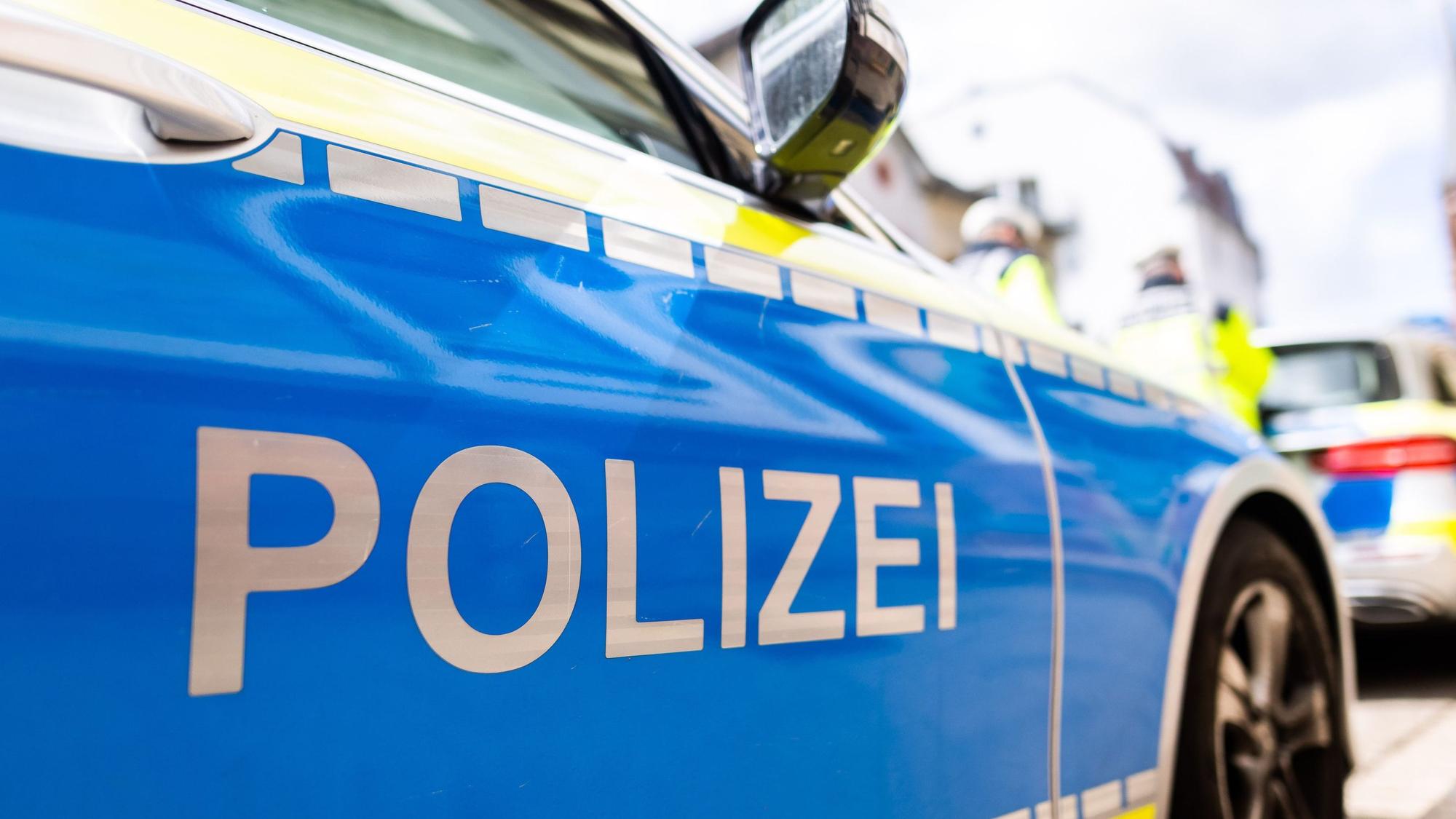 Zwei Einsatzfahrzeuge der Polizei stehen am Straßenrand.
