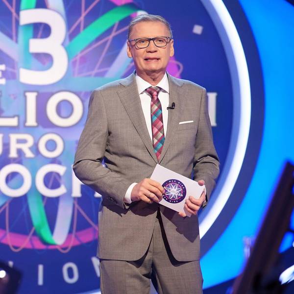 Moderator Günther Jauch steht in der Kulisse der RTL-Quizshow „Wer wird Millionär“ und hält eine Moderationskarte in der Hand.
