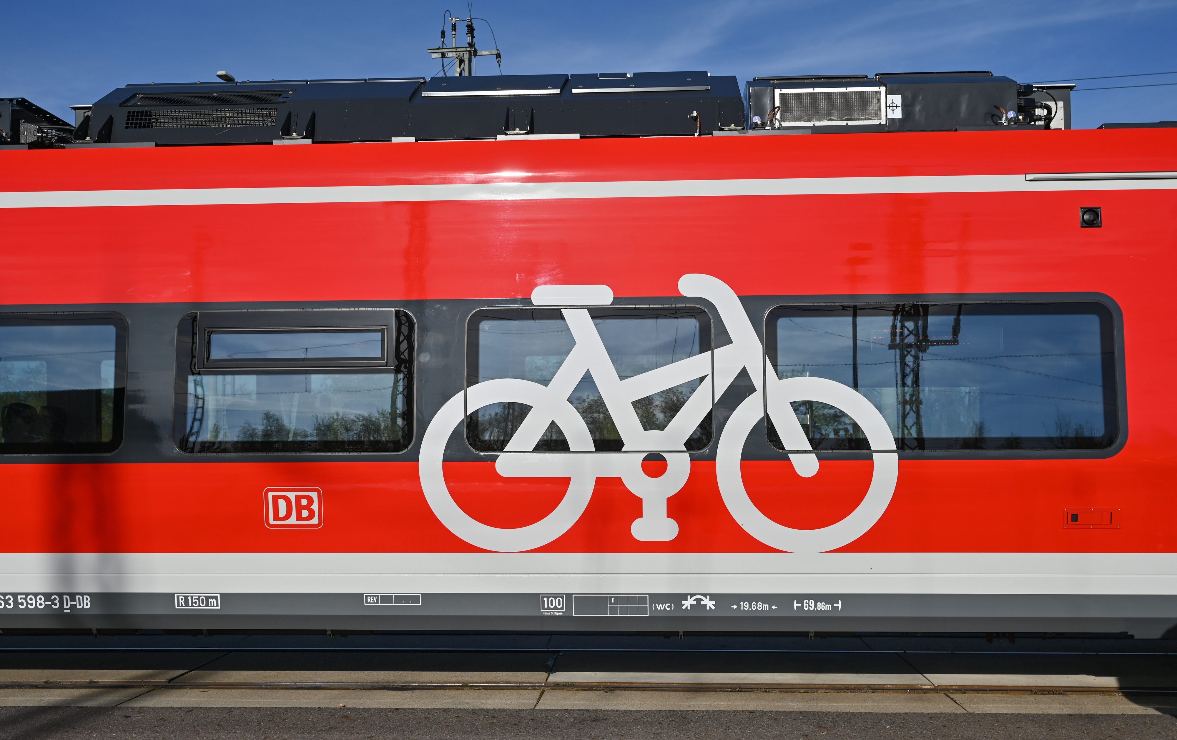 Eine rote Bahn mit Fahrrad-Aufdruck steht am Bahngleis.
