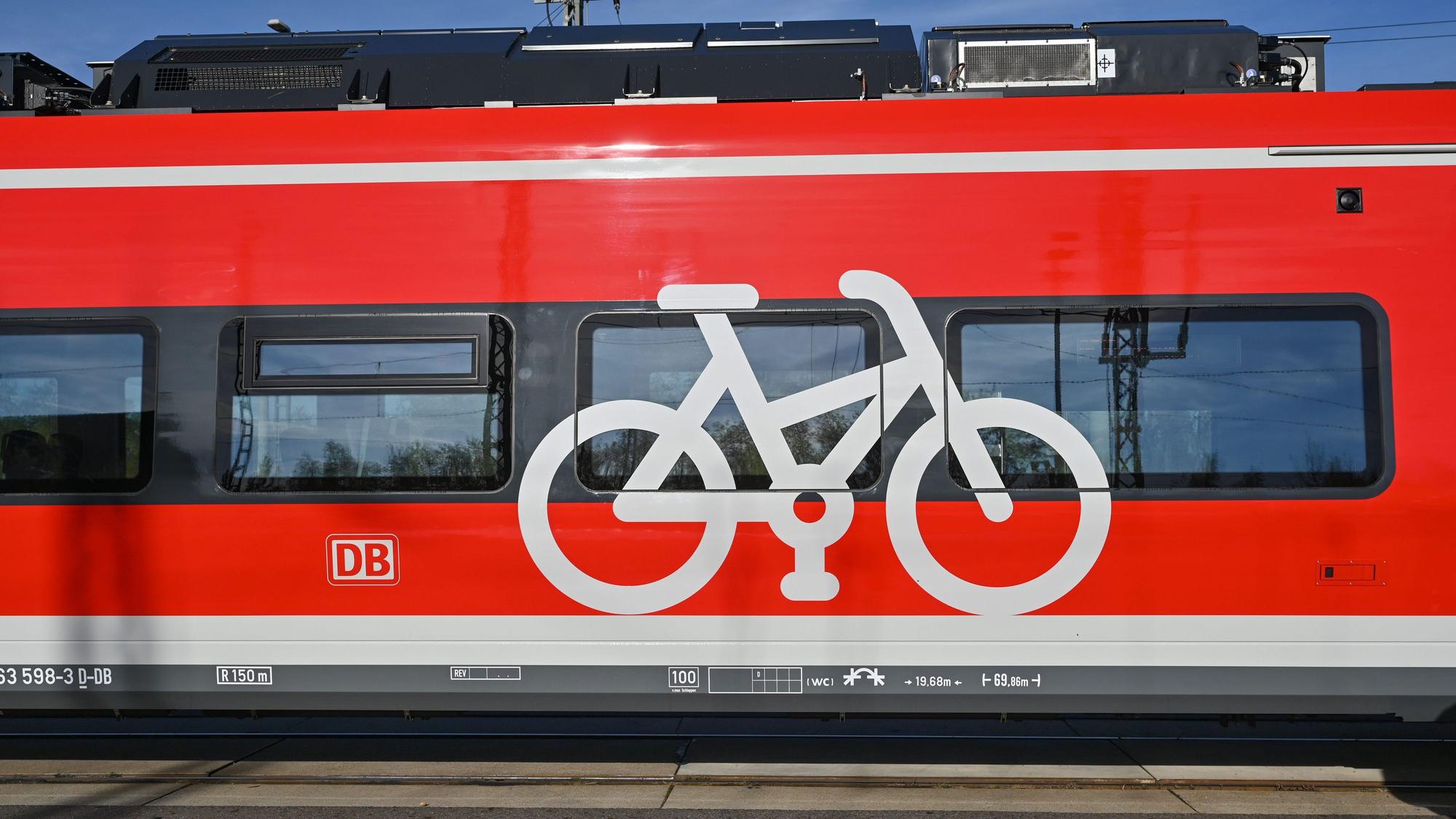 Eine rote Bahn mit Fahrrad-Aufdruck steht am Bahngleis.