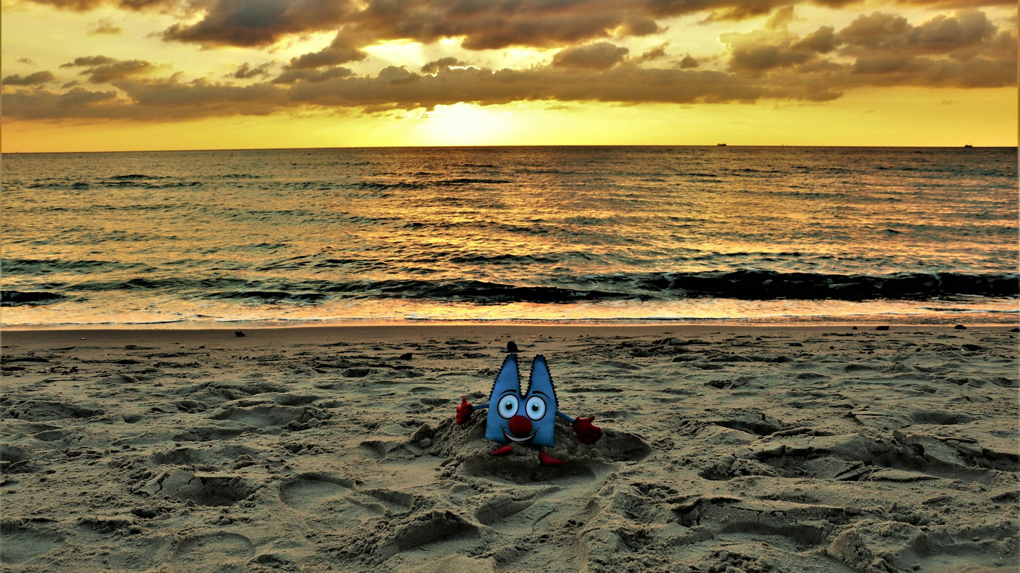 Ein Sonnenuntergang am Strand, in diesem wurde ein Dom-Plüschtier positioniert.