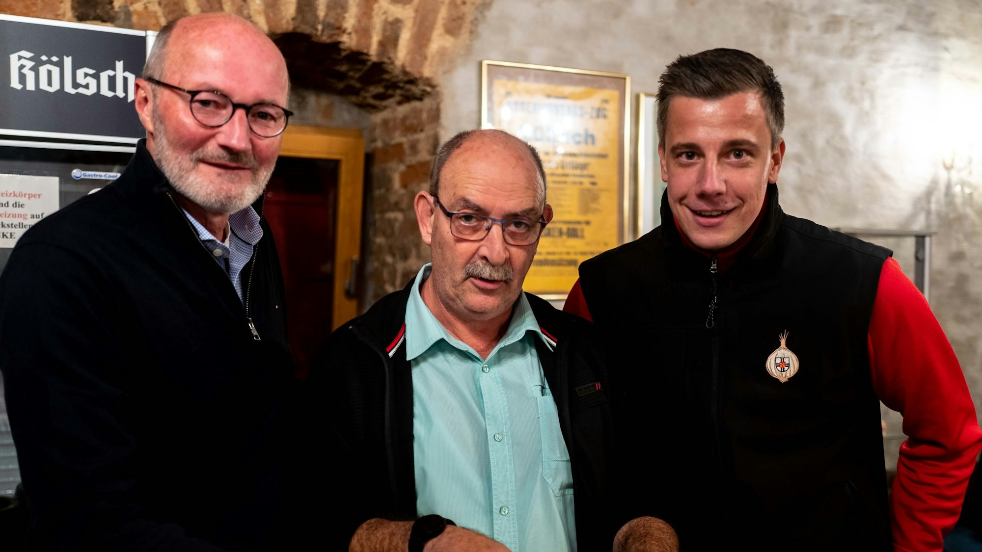 Drei Männer lächeln in die Kamera.