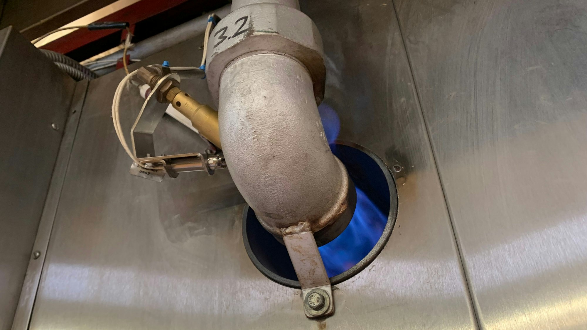 Ein blaue Gasflamme beheizt den Keksofen in der Fabrik.