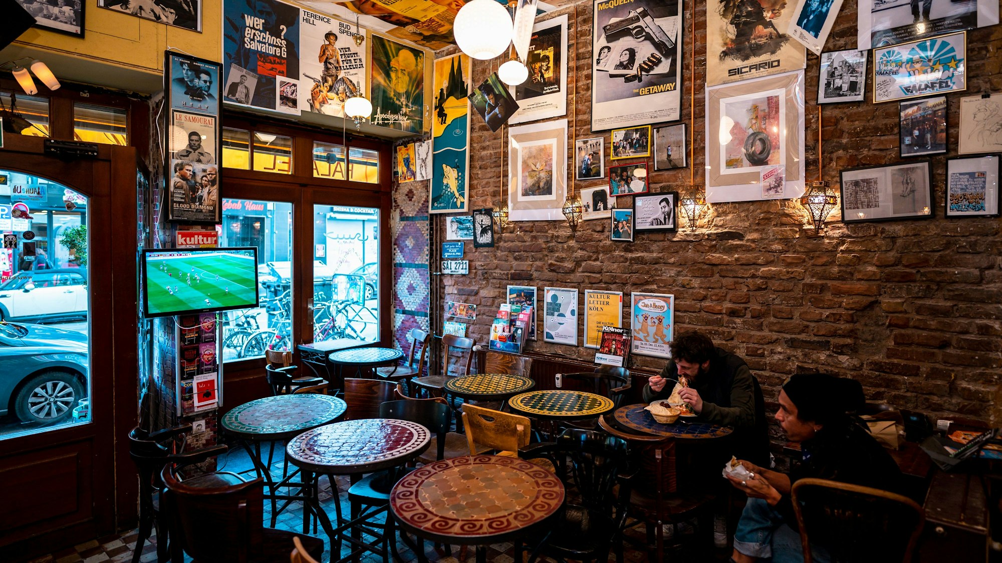 Halloumi-Teller statt WM-Euphorie: Das Bild zeigt zwei Gäste im Falafel-Laden "Habibi", die das deutsche WM-Spiel während der Mittagspause schauen.