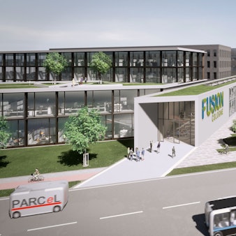 Eine Visualisierung des Industrieareals „Fusion Cologne“. Kastenartige Gebäude mit Glasfassaden und Begrünung stehen an einer Straße, auf der selbstfahrende Autos fahren.