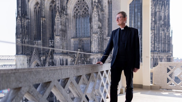 02.05.2022, Nordrhein-Westfalen, Köln: Kardinal Rainer Maria Woelki, Erzbischof von Köln, steht nach einem Pressegespräch auf dem Balkon des Domforum - im Hintergrund der Kölner Dom.