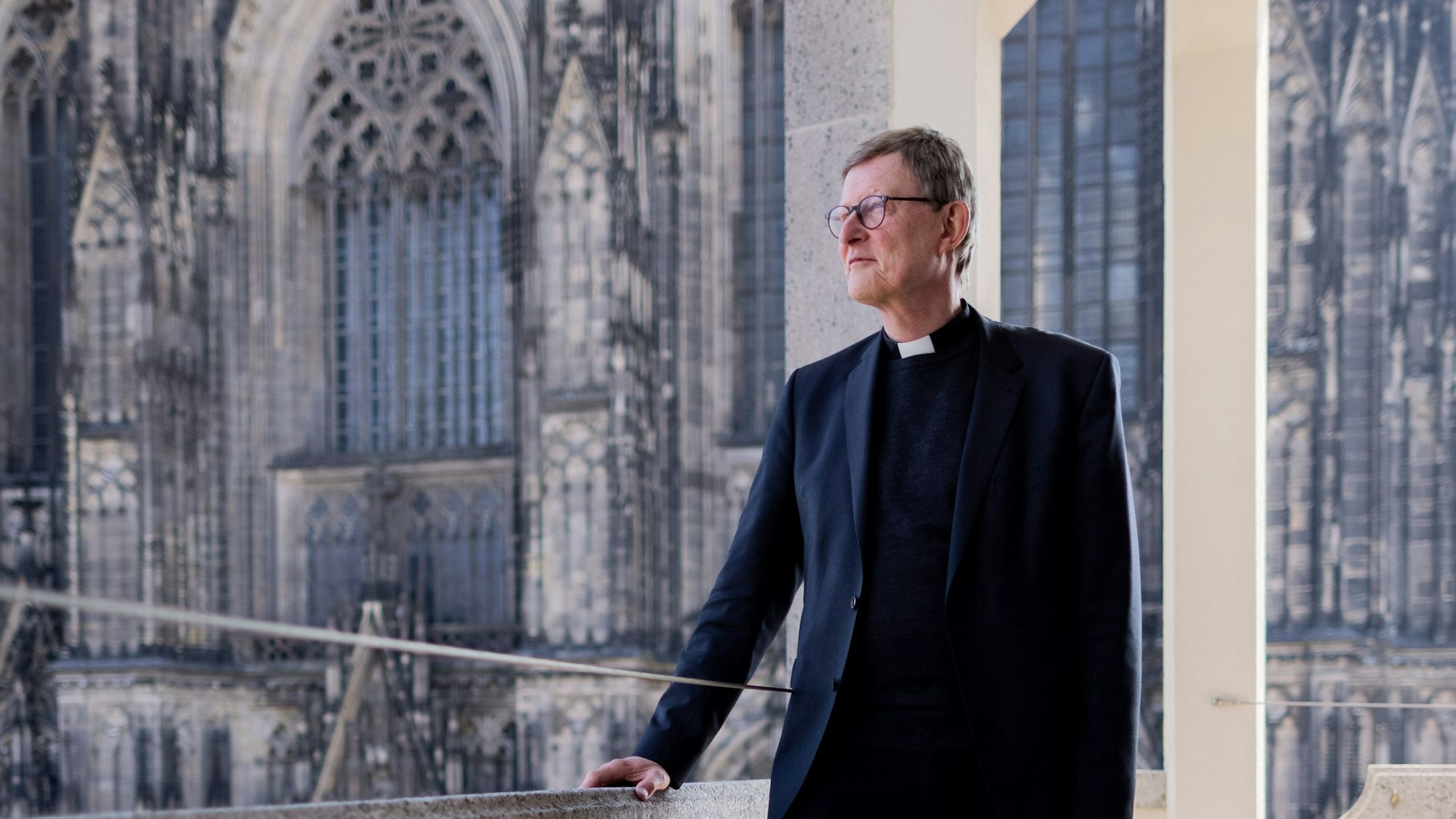 02.05.2022, Nordrhein-Westfalen, Köln: Kardinal Rainer Maria Woelki, Erzbischof von Köln, steht nach einem Pressegespräch auf dem Balkon des Domforum - im Hintergrund der Kölner Dom.