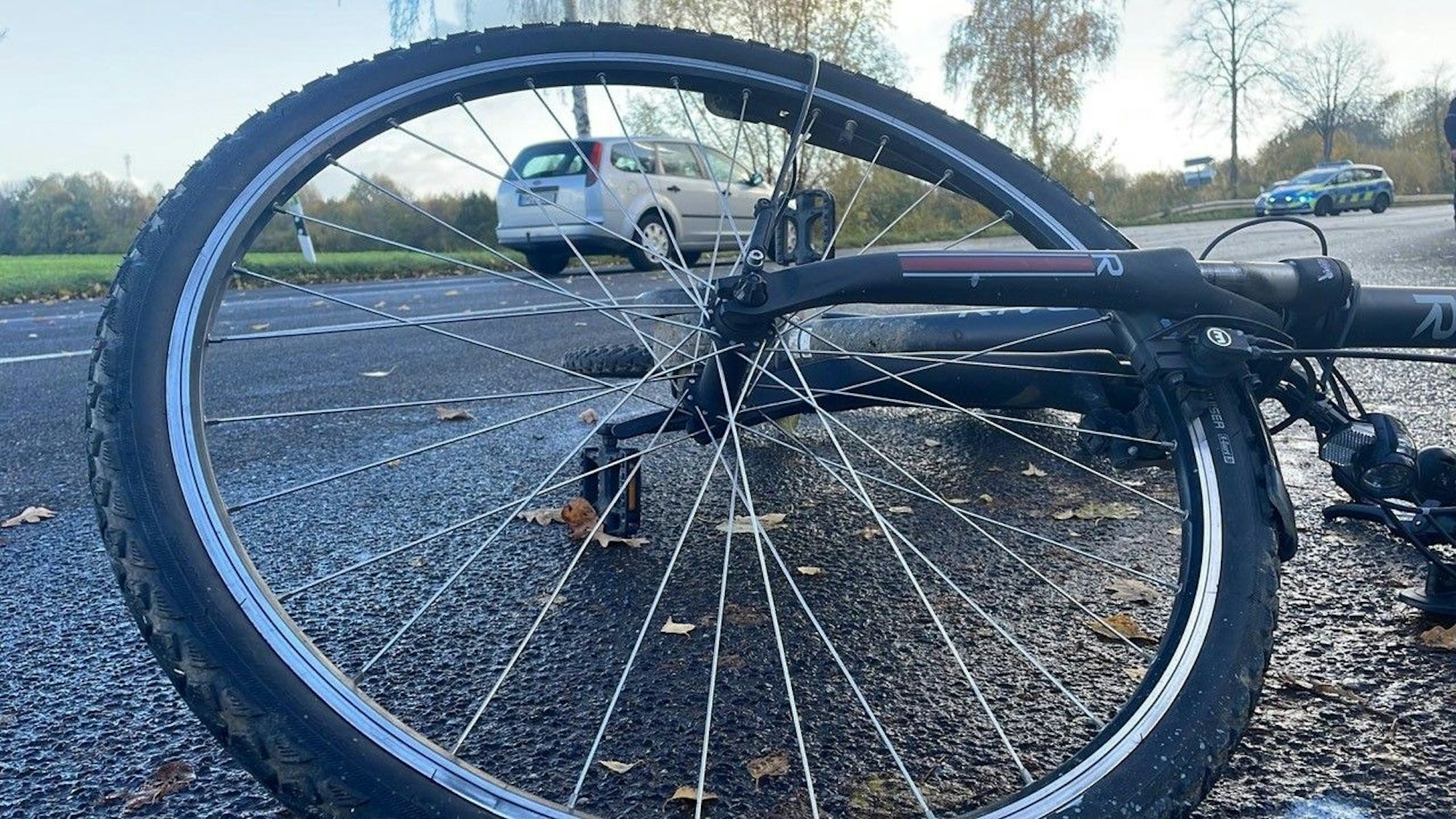 Ein Fahrrad liegt auf der Straße an der Unfallstelle.