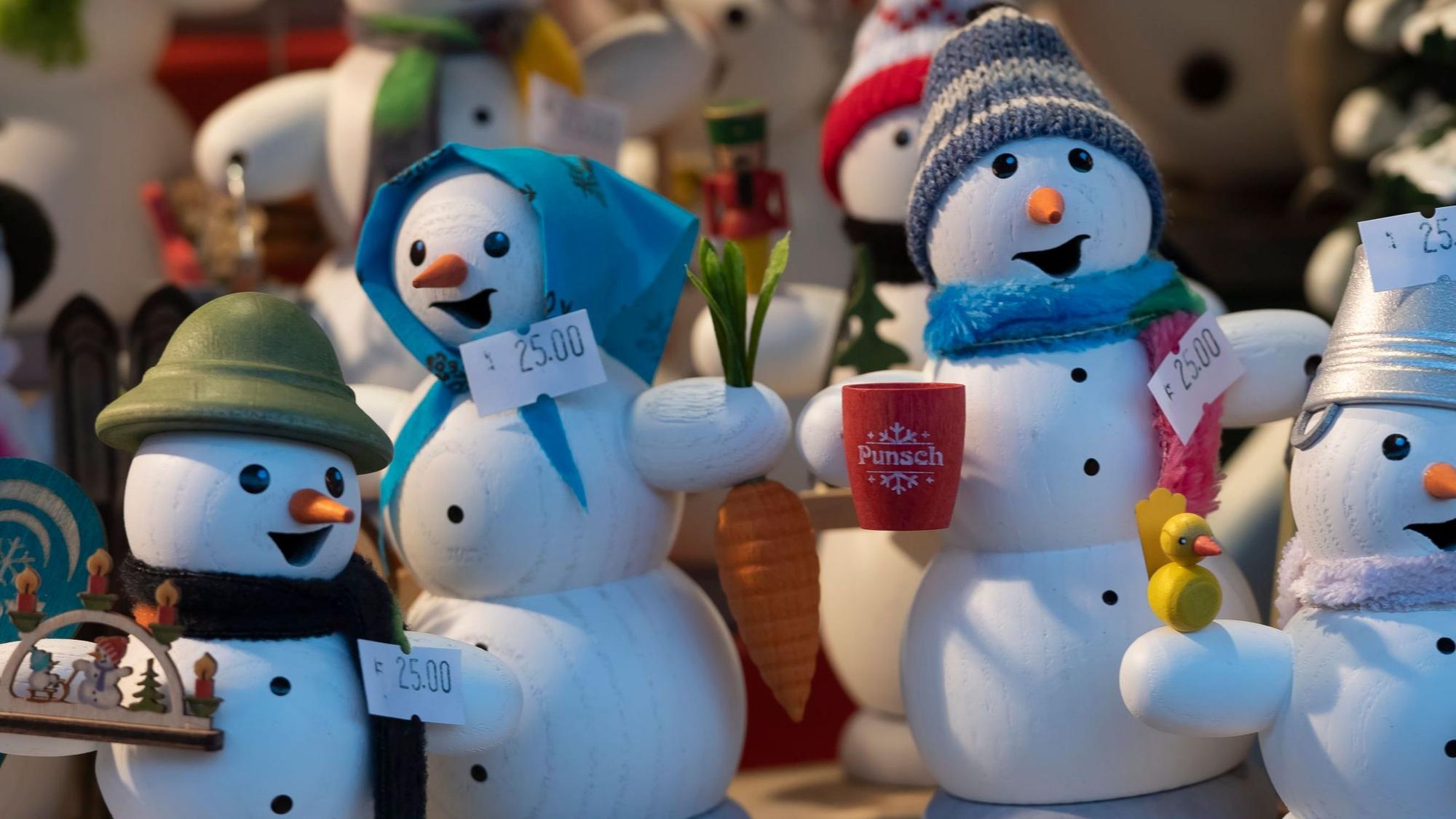 Weihnachtsfiguren stehen in einer Bude eines Weihnachtsmarktes.