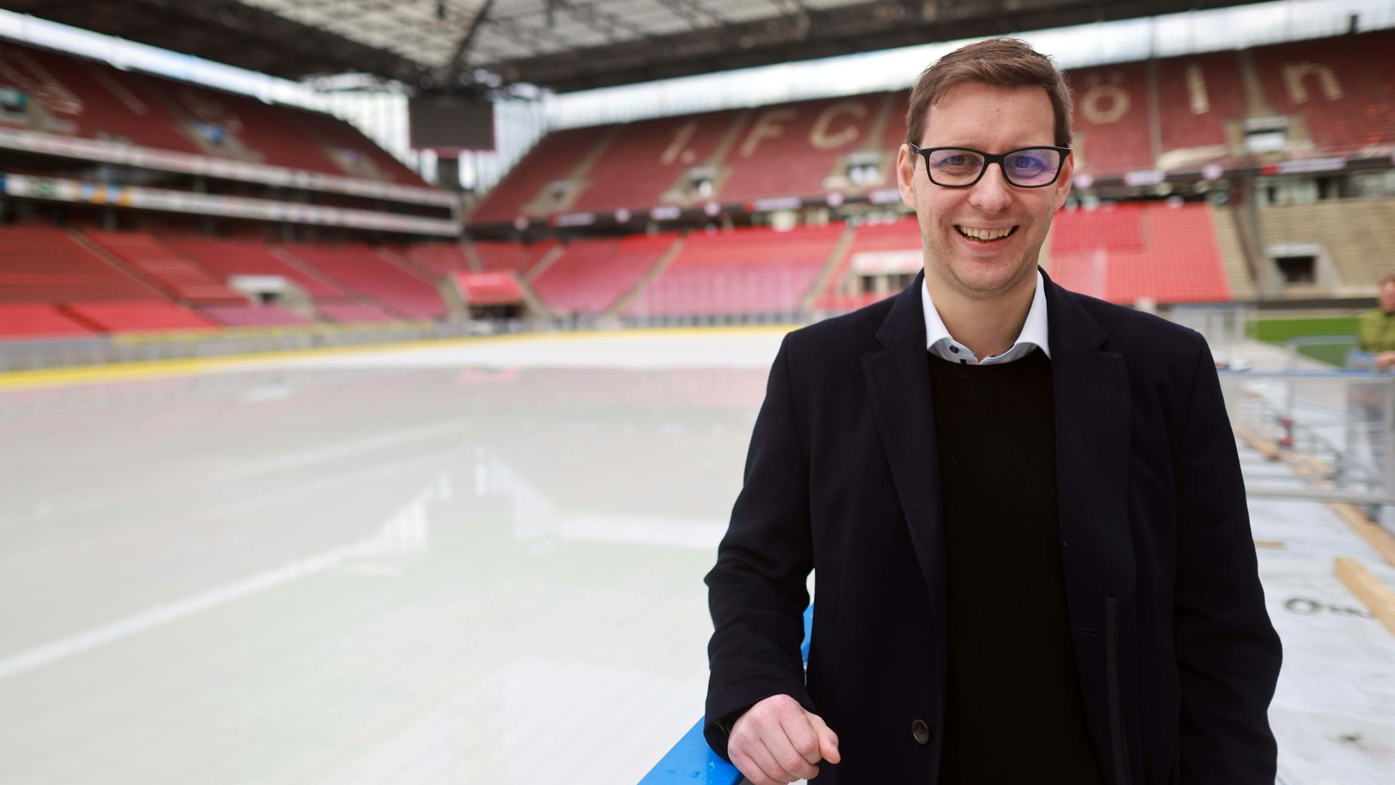 Projektleiter Torsten Pfennig von den Kölner Haien steht an der Bande der Eisfläche, die derzeit im Innenraum des Rheinenergie-Stadions aufgebaut wird.