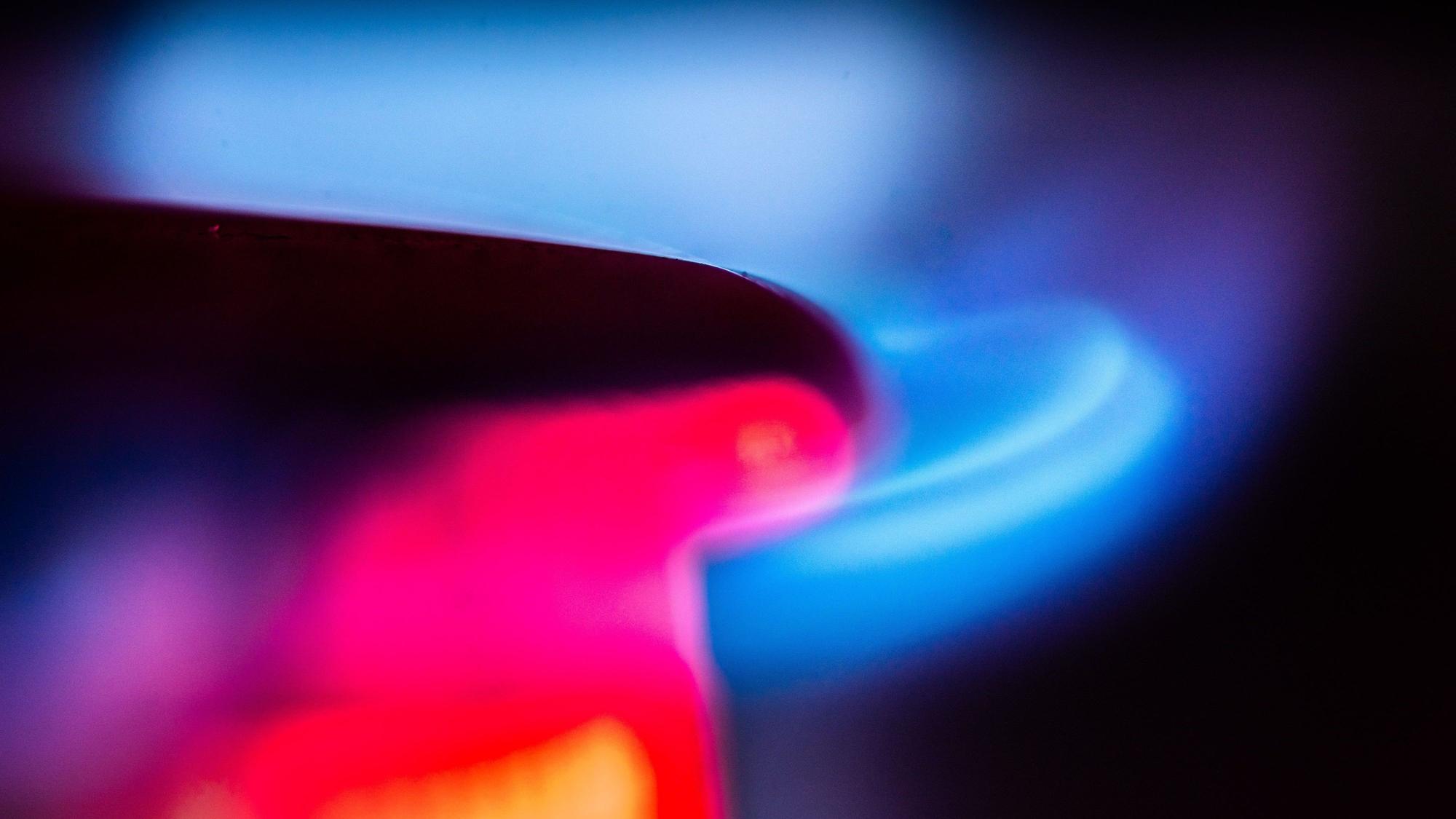 Die Flamme eines Gasherdes brennt in einer Küche.