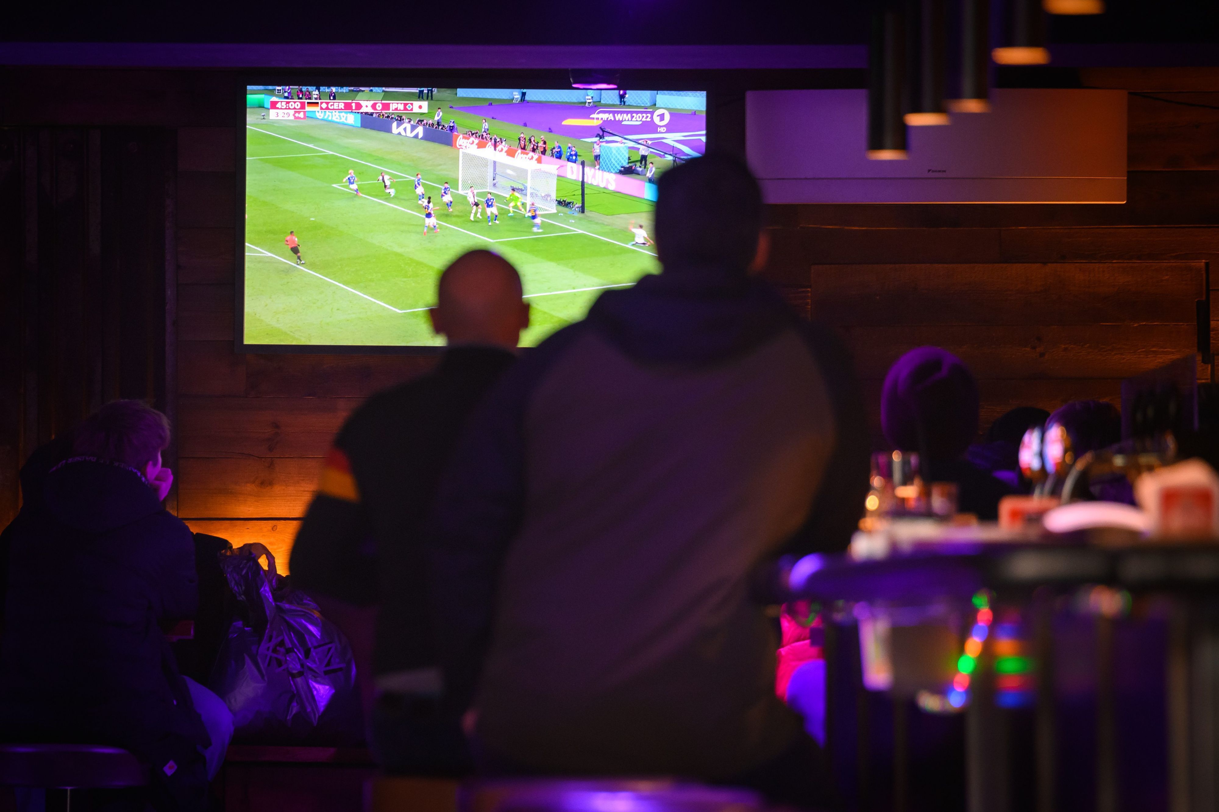 Gäste einer Kneipe im Stadtteil St. Pauli schauen gegen 14:48 Uhr auf einem Fernseher das erste Spiel der Deutschen Nationalmannschaft gegen Japan bei der umstrittenen WM in Katar.