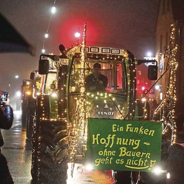 Ein leuchtender Traktor rollt mit der Aufschrift „Ein Funken Hoffnung – Ohne Bauern geht es nicht“ durch Overath-Heiligenhaus.