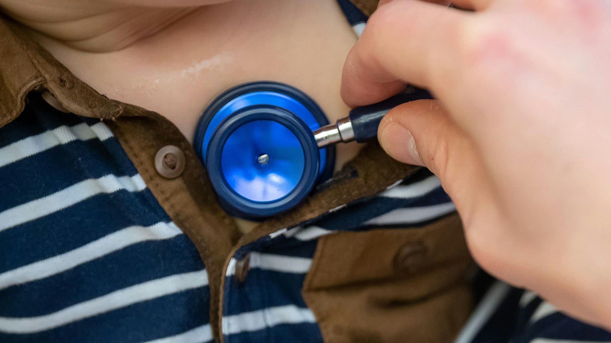 Ein Arzt untersucht ein Kind mit einem Stethoskop.