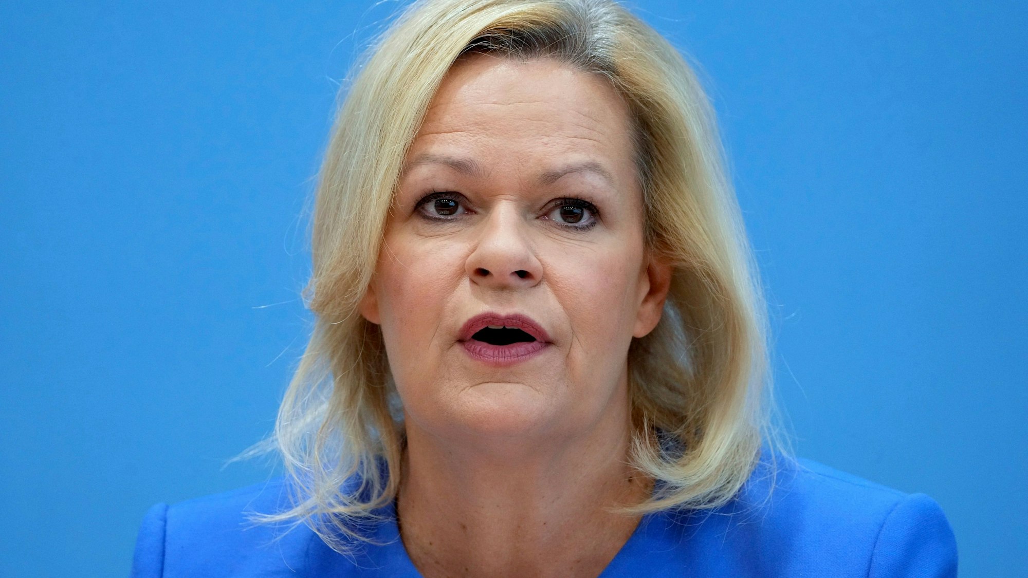 Bundesinnenministerin Nancy Faeser schaut bei einer Pressekonferenz in Richtung der Kamera.
