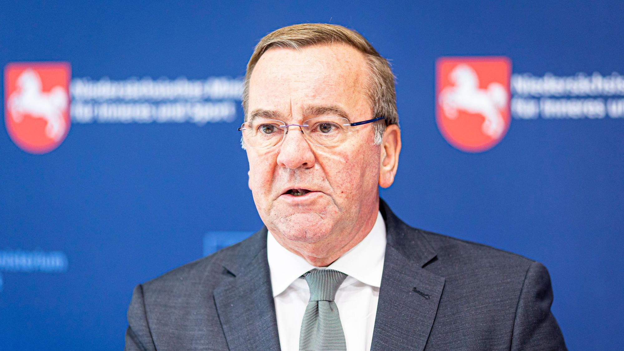 Boris Pistorius (SPD), Innenminister von Niedersachsen, gibt ein Pressestatement beim Treffen kommunaler Spitzenverbände in Niedersachsen ab. Er guckt ernst an der Kamera vorbei. Im Hintergrund sind Wappen von Niedersachsen zu sehen. (Archivbild)