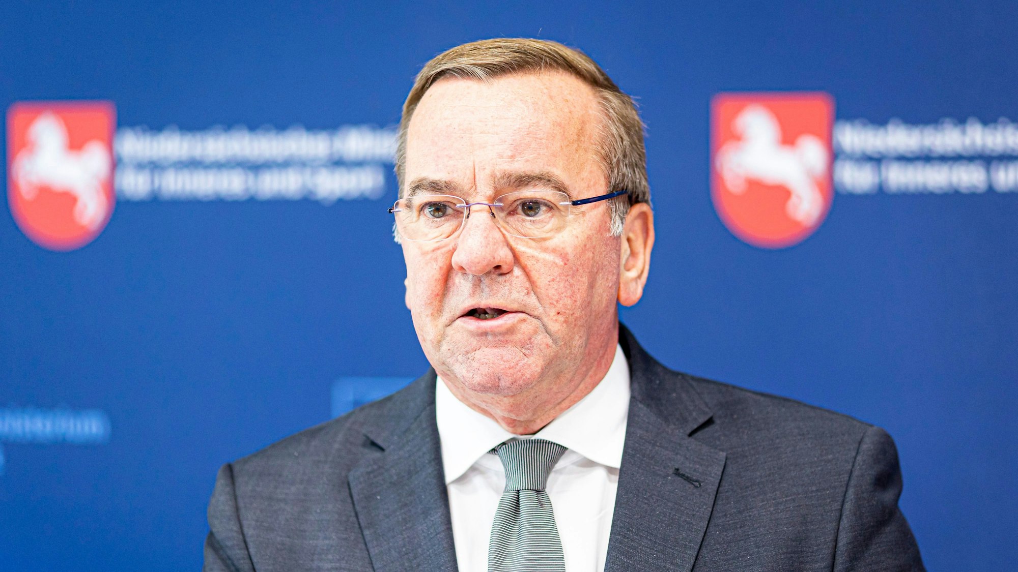Boris Pistorius (SPD), Innenminister von Niedersachsen, gibt ein Pressestatement beim Treffen kommunaler Spitzenverbände in Niedersachsen ab. Er guckt ernst an der Kamera vorbei. Im Hintergrund sind Wappen von Niedersachsen zu sehen. (Archivbild)