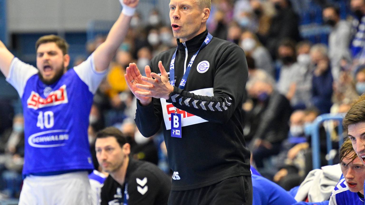 VfL-Trainer Gudjon Valur Sigurdsson steht am Rand des Handballfeldes und gestikuliert mit den Händen. Im Hintergrund jubelt VfL-Kreisläufer Jonas Stüber.