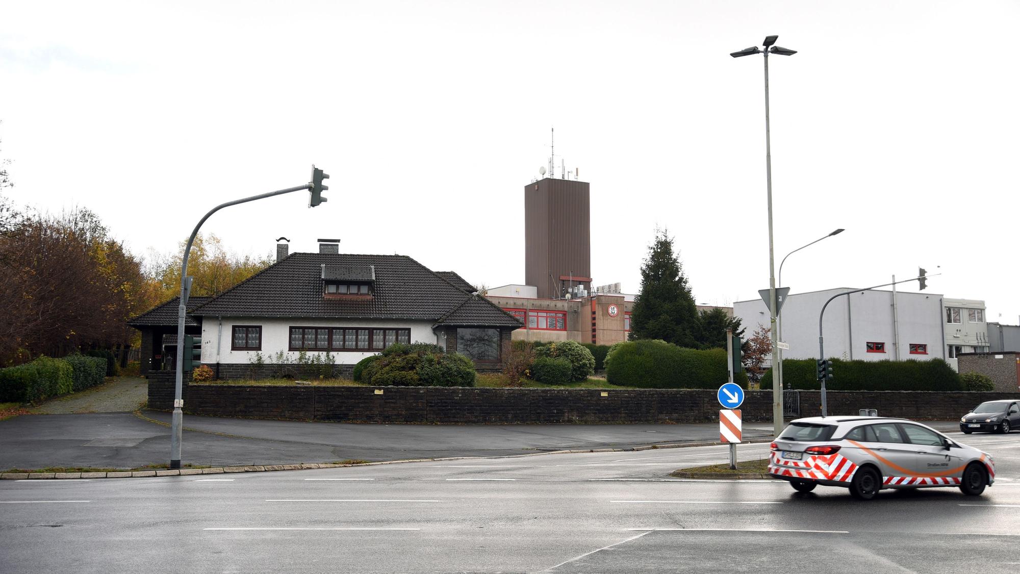 Blick auf eine Ampelkreuzung, im Hintergrund ein Wohnhaus und dahinter das Brandschutzzentrum in Marienheide-Kotthausen