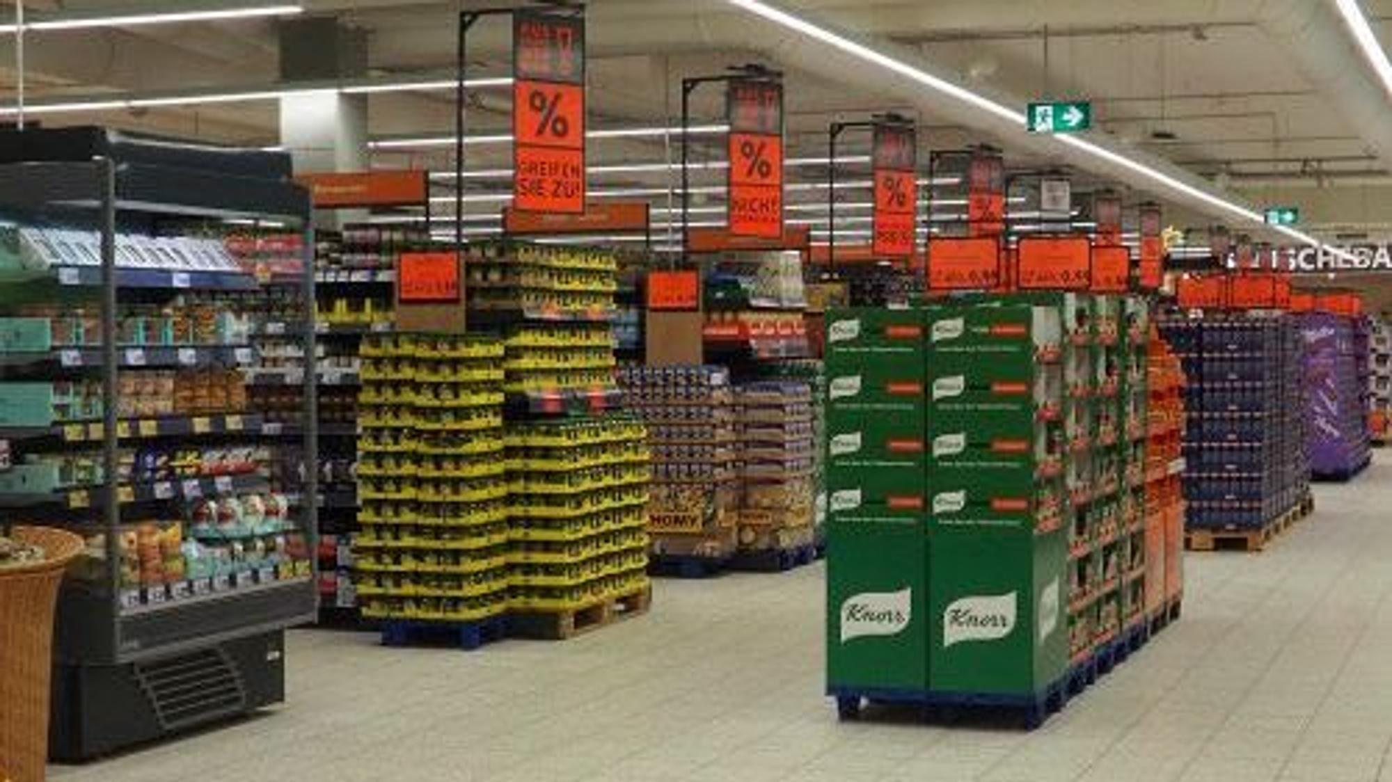 Ein Blick in einen Gang beim Lebensmittel-Discounter Kaufland. Auf großen Schildern werden Rabatte auf Produkte beworben.