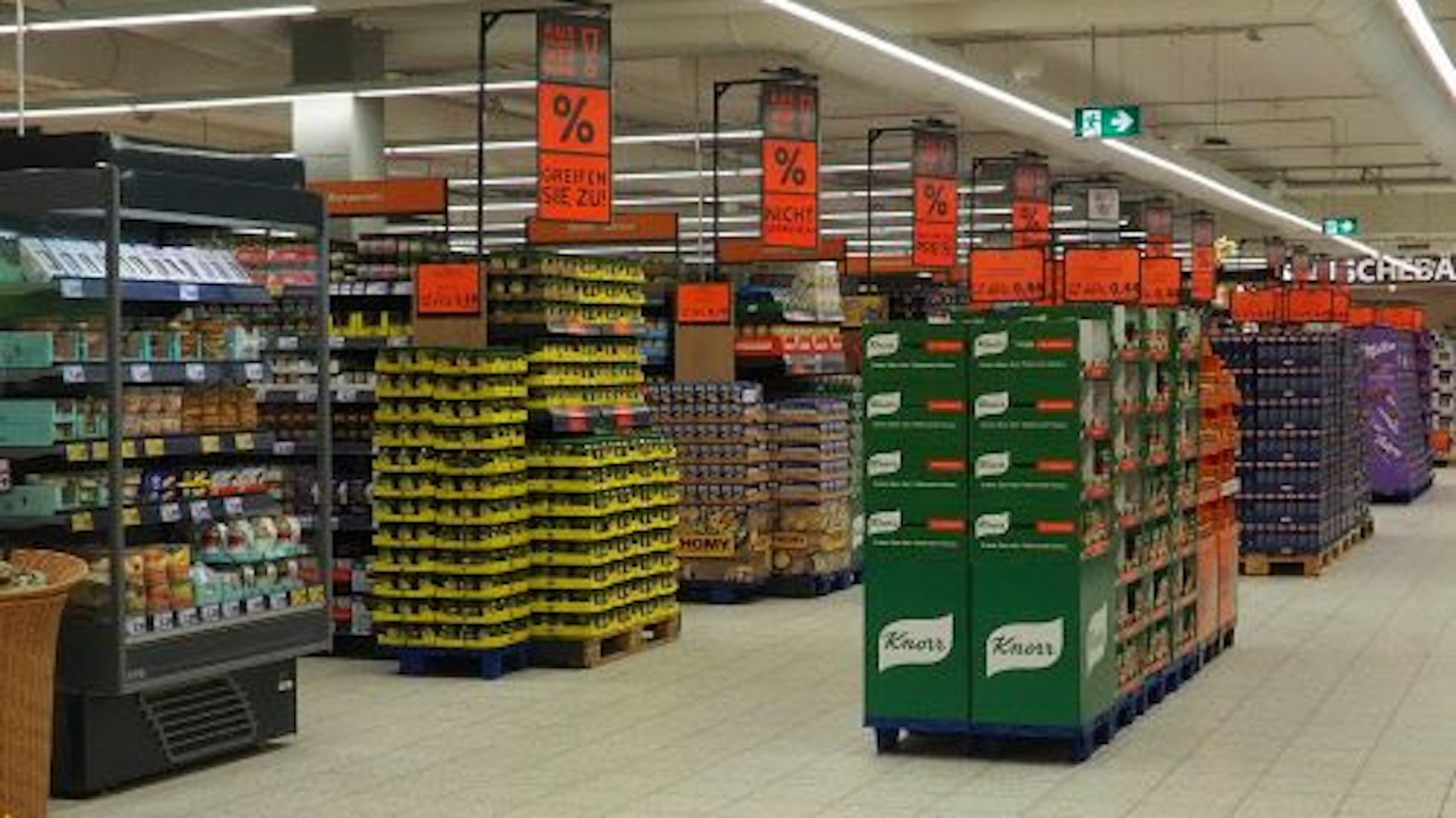 Ein Blick in einen Gang beim Lebensmittel-Discounter Kaufland. Auf großen Schildern werden Rabatte auf Produkte beworben.