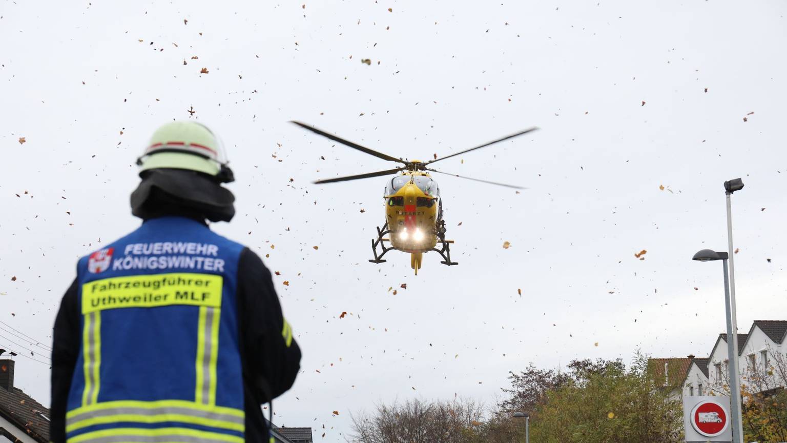 Ein Rettungshubschrauber fliegt vor einem Feuerwehrmann in die Luft.