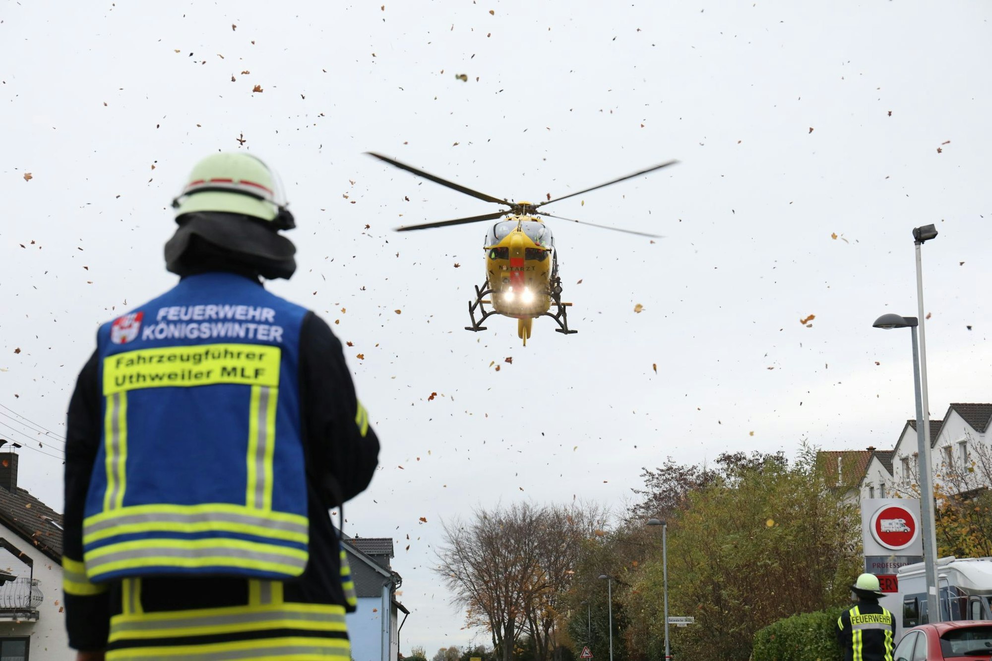 Ein Rettungshubschrauber fliegt vor einem Feuerwehrmann in die Luft.