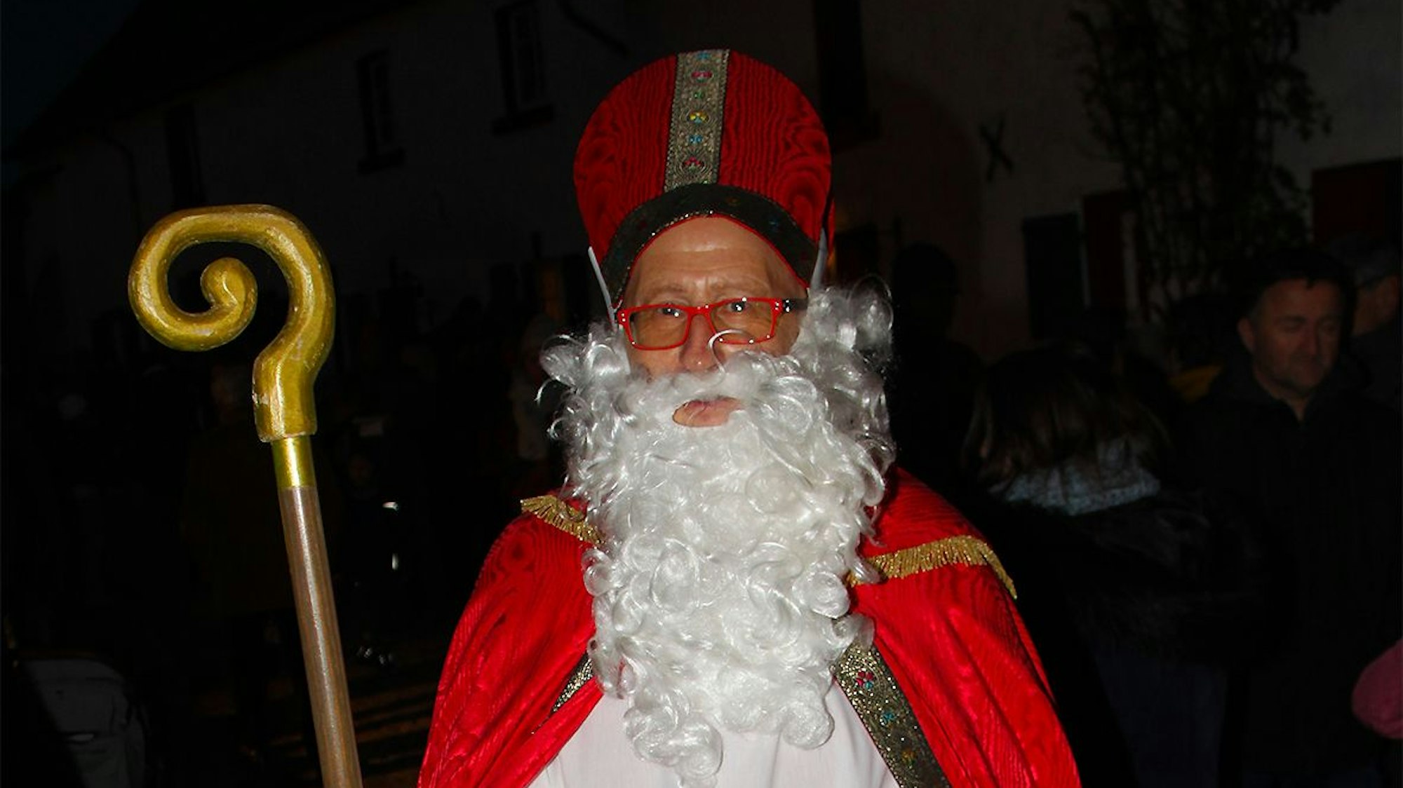 Heinz-Bert Weimbs, Vorsitzender des Ortskartells, ist als Nikolaus unterwegs. In seiner Hand hält er einen Korb mit Süßigkeiten für die Kinder.