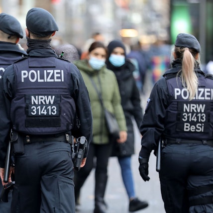 Polizisten laufen auf der Kölner Schildergasse Streife.